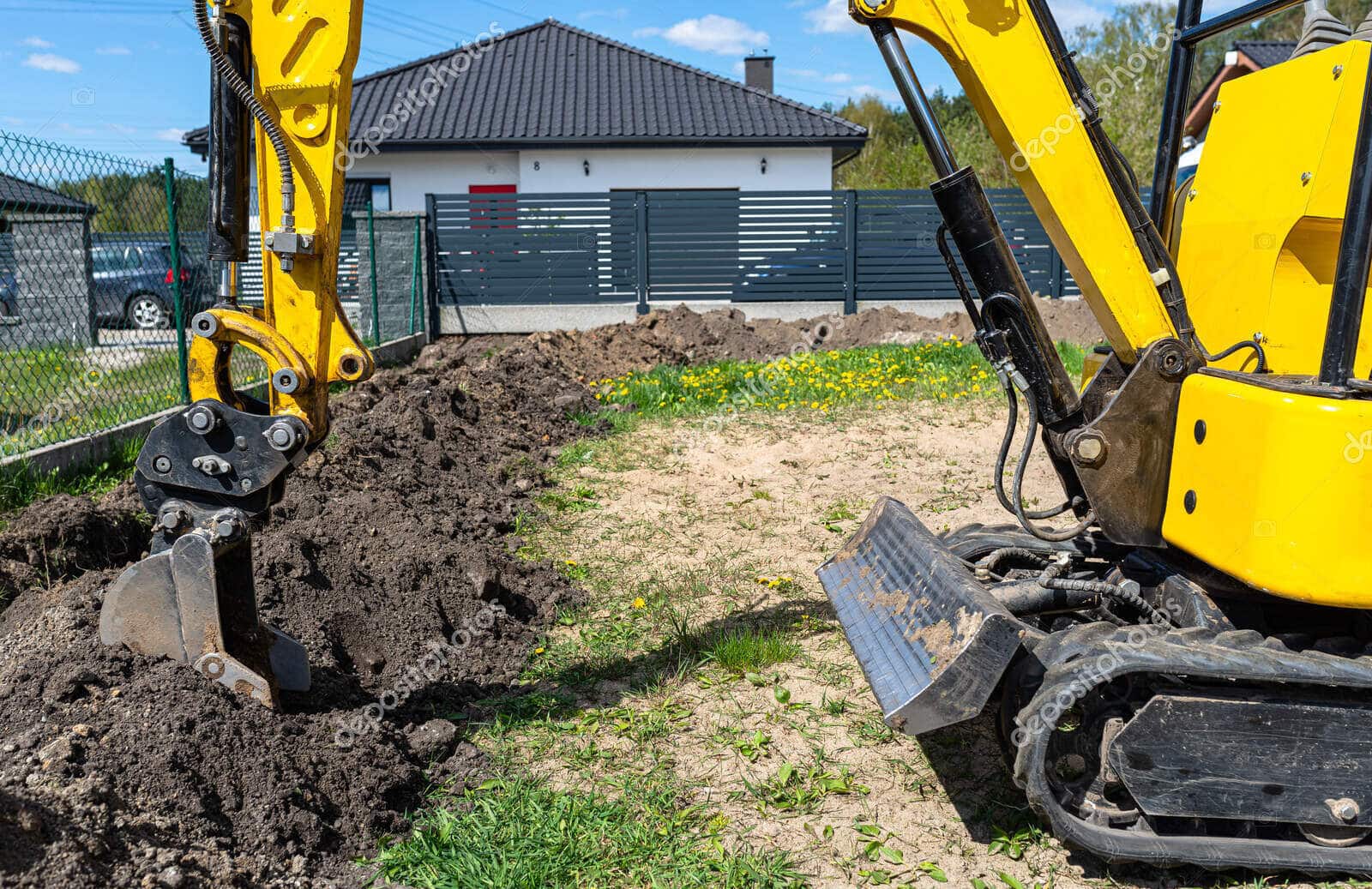 Mini koparka wykopuje dół w ogrodzie, przygotowując teren