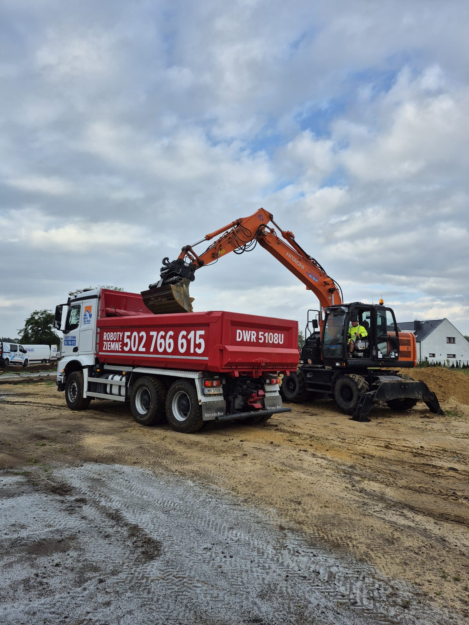 Operator koparki wykonuje wykop w terenie